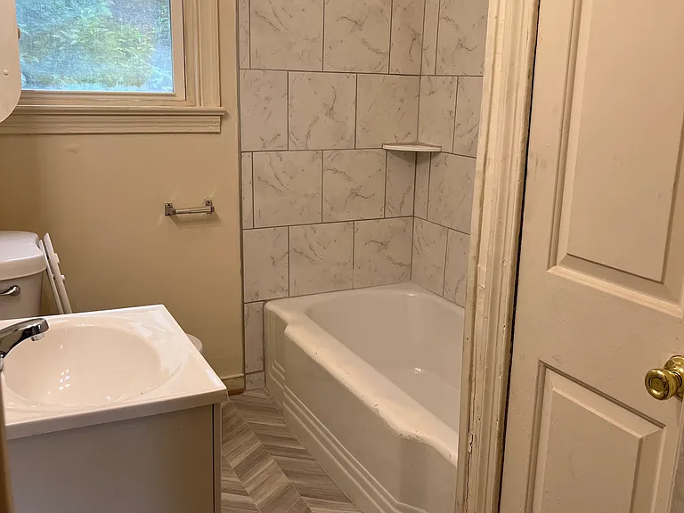 Remodeled bathroom with new wall tile, new vanity