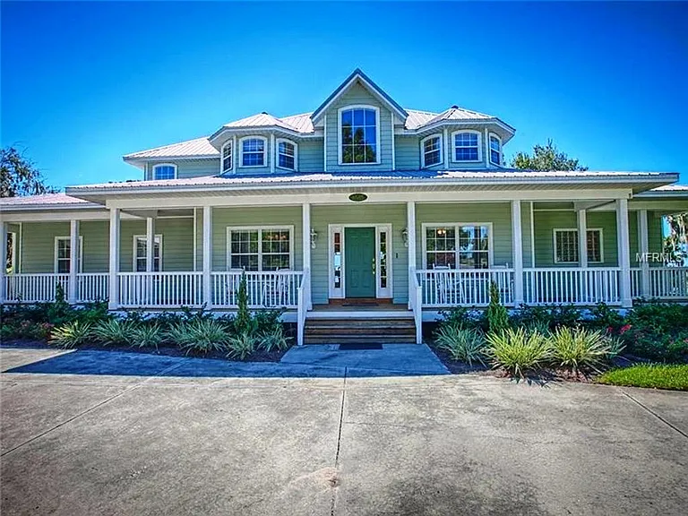 Another view of the front of the house with its wrap around porches, two story foyer, upper craft rooms, DR left of the main door and Office right of the main door