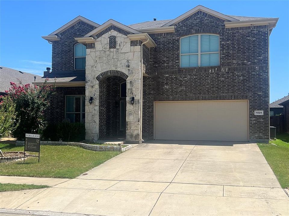 French country inspired facade with stone siding, an attached garage, brick siding, and concrete driveway