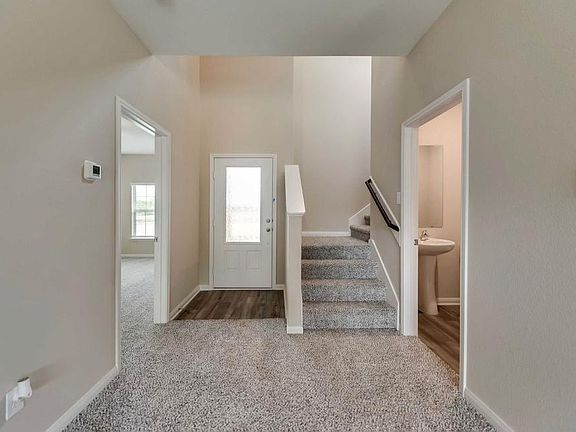 Entrance. Stairs to the second floor. Half bath on the right, and master bedroom on the left.