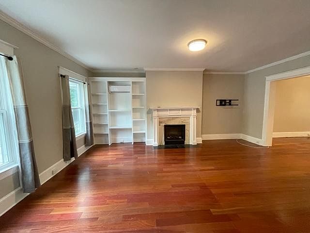 Living Room (20x14)--hardwood floors, crown molding, gas fireplace, built-in bookshelf, 9.5 ft ceilings, overhead light, windows facing Connecticut Avenue