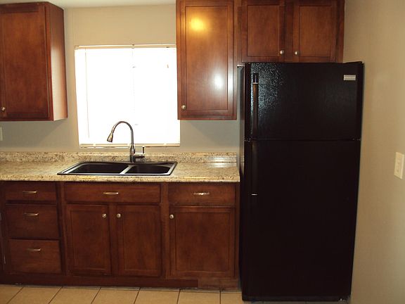 Kitchen with pull-out spray faucet and fridge with icemaker.