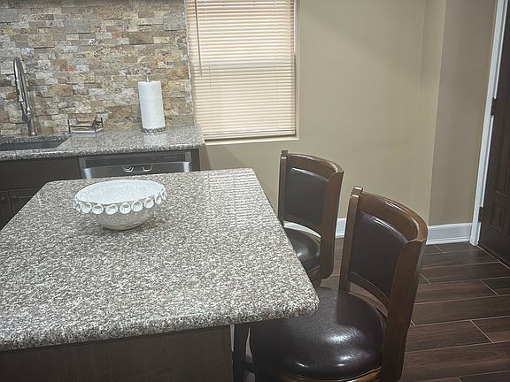 The island located in the kitchen area with two stools.
