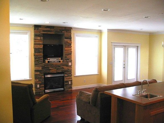 Living room area, view of cherry wood flooring, fireplace.