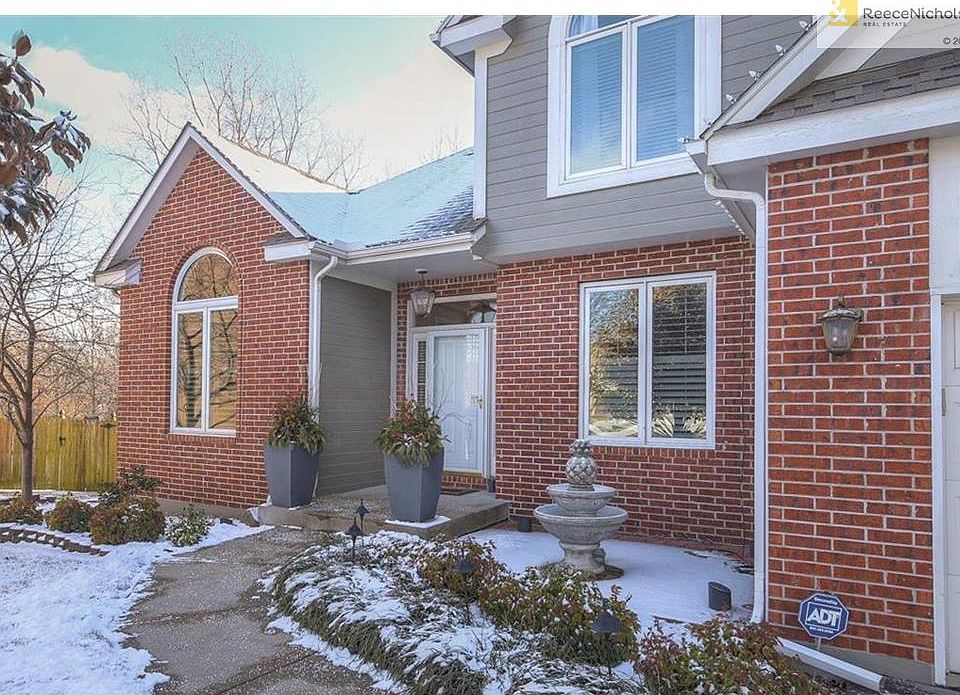 Home is nestled in a cul-de-sac with a brick front and beautiful mature landscaping and fountain.