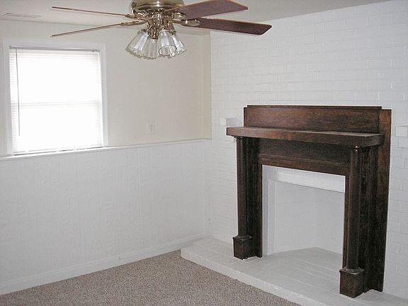 Master bedroom with fireplace and ceiling fan