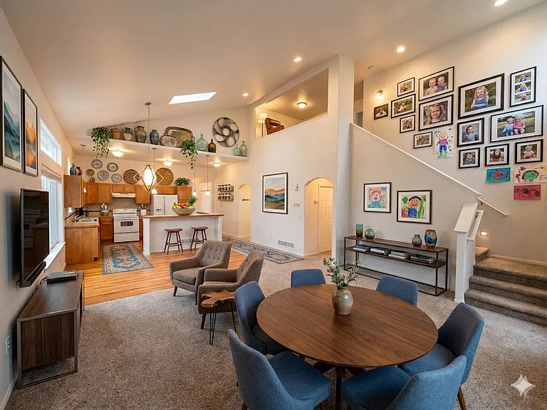 View from the living room toward the kitchen, stairs, and loft. NOTE: Home is unfurnished.