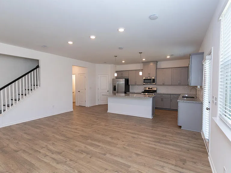 Spacious kitchen featuring a refrigerator, sink, and ceiling fan for added comfort.