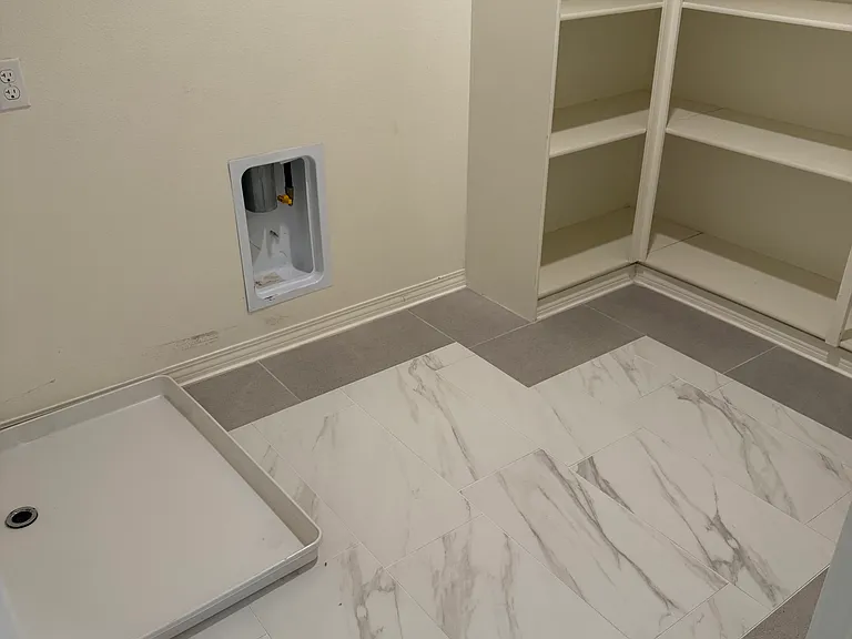 View of laundry room with hook-ups and large amount of storage.