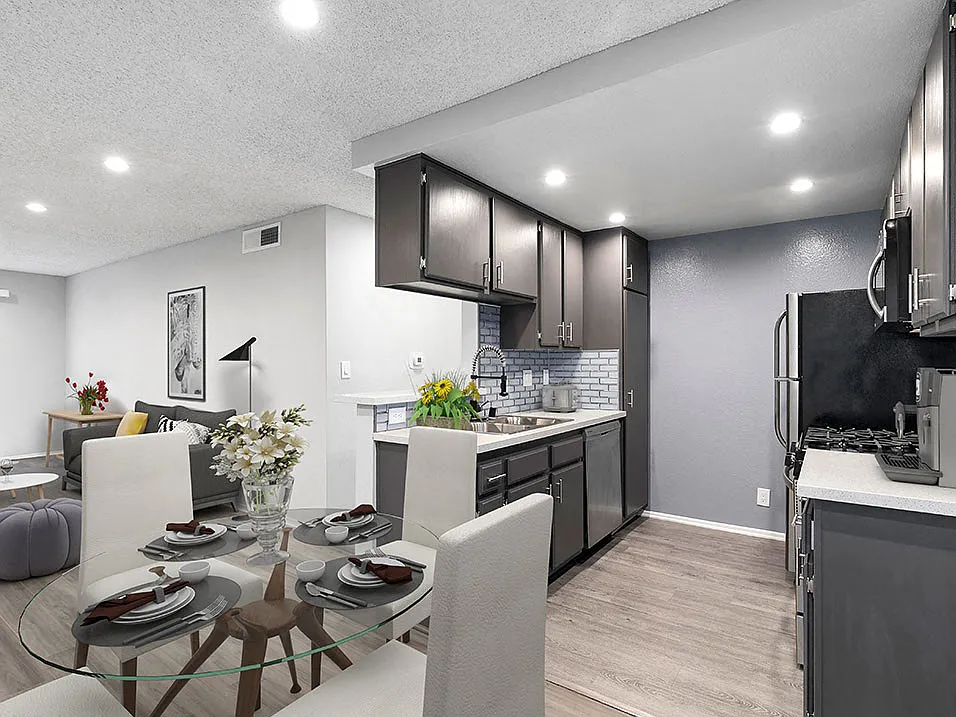 Hardwood floor dining room with view of tiled kitchen area.