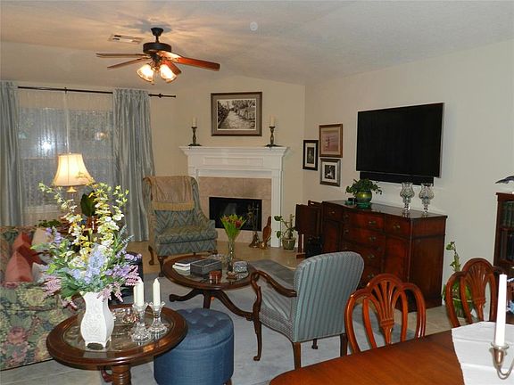 Large family room with tile flooring and gas log fireplace.