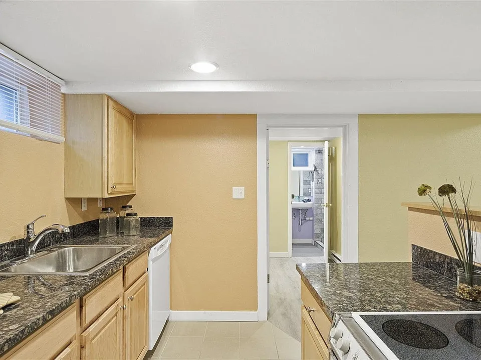Updated kitchen with granite countertops, dishwasher, fridge, and stove.