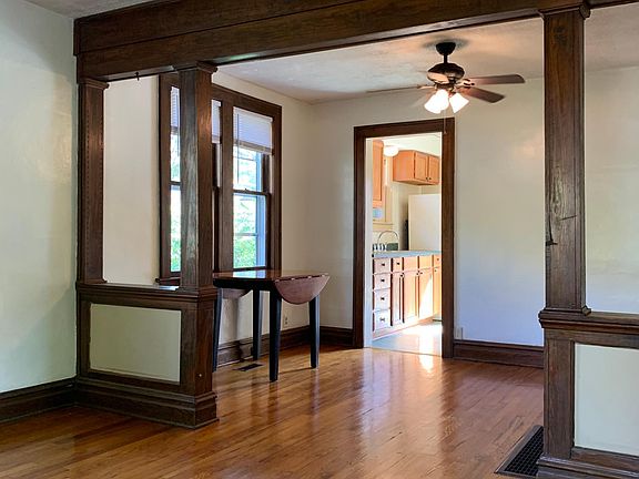 View from front entrance showing living room, dining room with ceiling fan and kitchen.