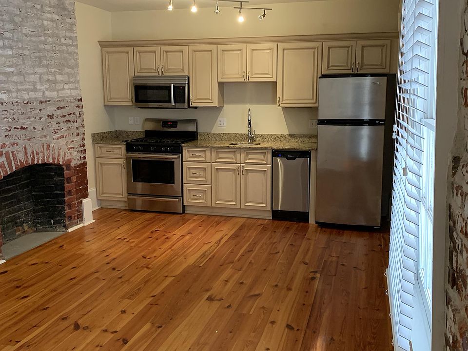 Open living / kitchen / dining area with large window for natural lighting. Task lighting in kitchen