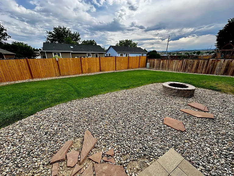 Fenced back yard with fire pit and small garden box