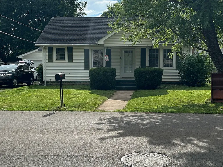 Front of house, driveway on left with two-car garage straight ahead.