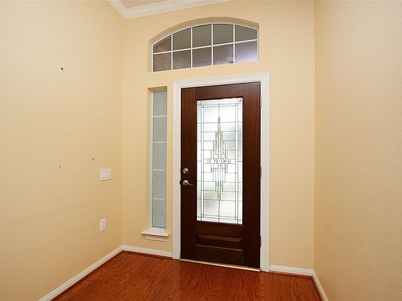 Entry has high ceiling, crown molding and wood floors