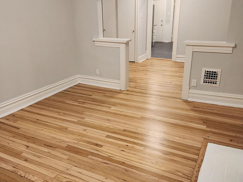 View from the front door of the front two rooms with new hardwood floors and connecting archway