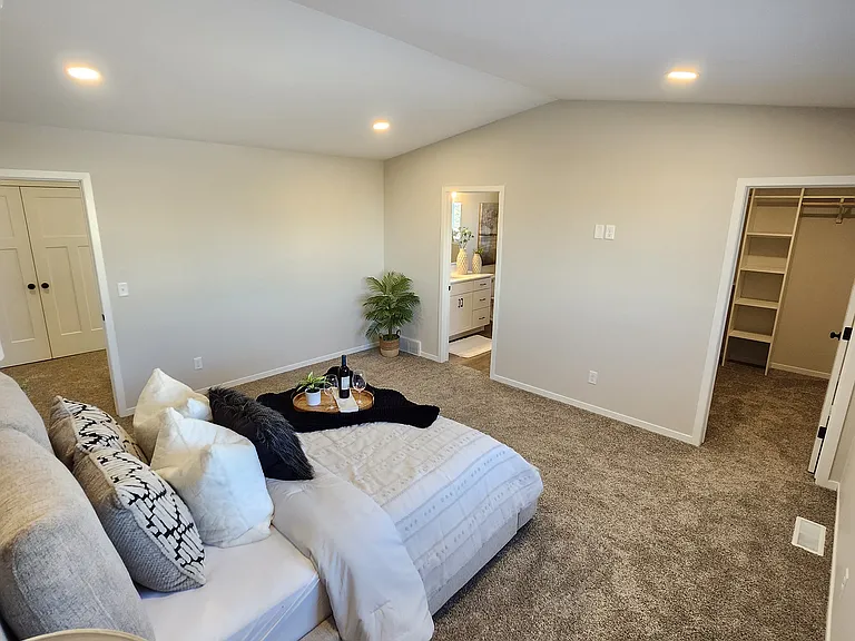 Extra large primary bedroom looking to closet and bathroom. (Pictures are of another unit with similar finishes and features.)