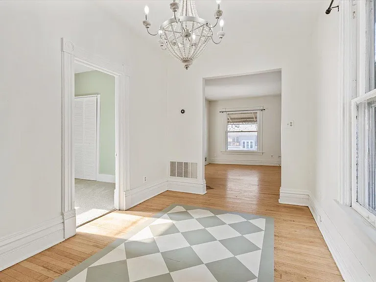 Charming dining room features a stunning chandelier and hand painted rug for added charm.
