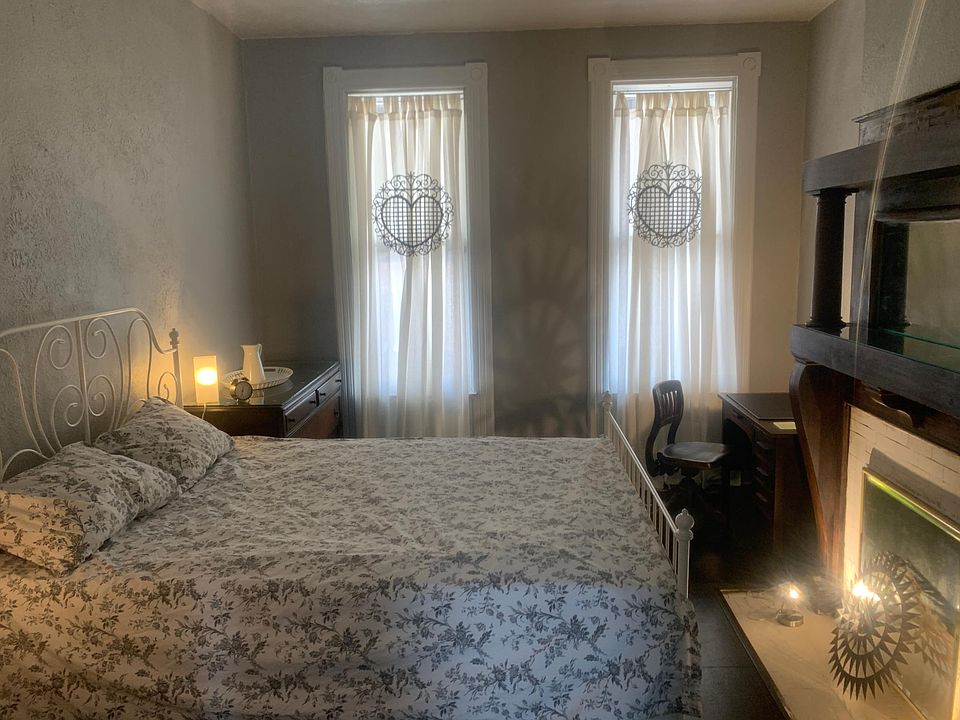 Bedroom with original fireplace mantel.