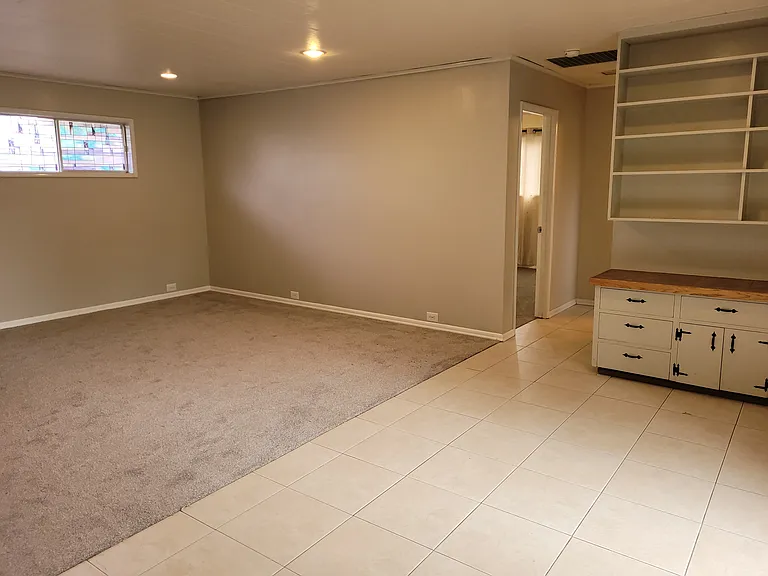 The spacious back living room has tile and new carpet. Game night is a breeze with the ample floor space, built in storage cabinetry, and counter tops on both sides of the room.
