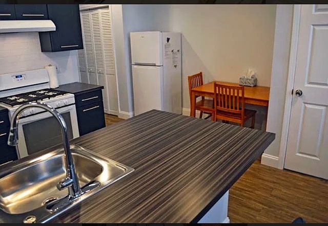 Modern designed kitchen with patterned counter, stainless steel sink and gas stove.