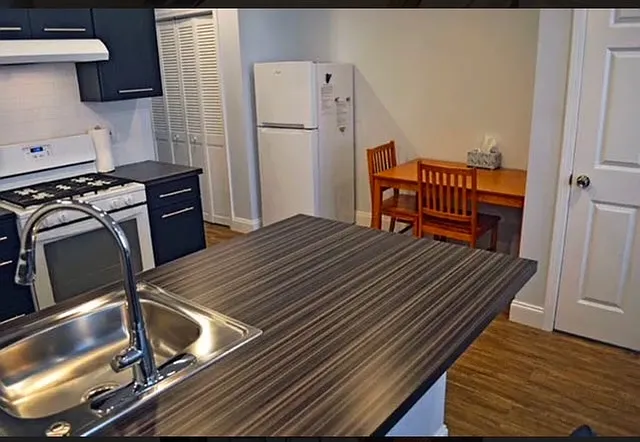 Modern designed kitchen with patterned counter, stainless steel sink and gas stove.