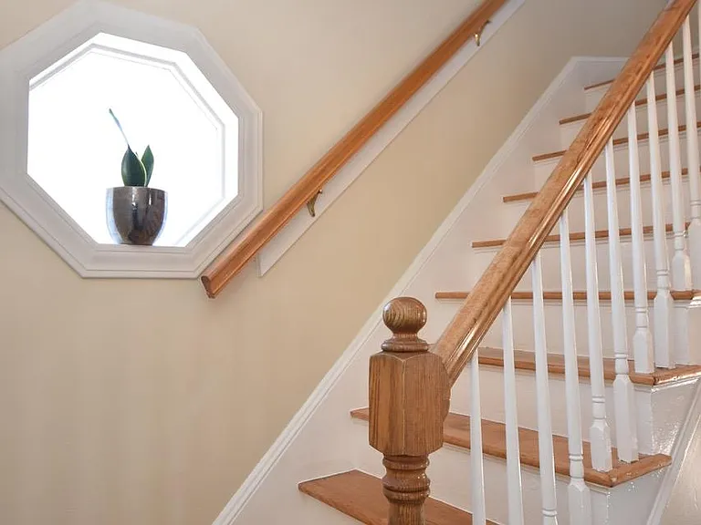 Stairs to bedrooms and bath with a decorative window