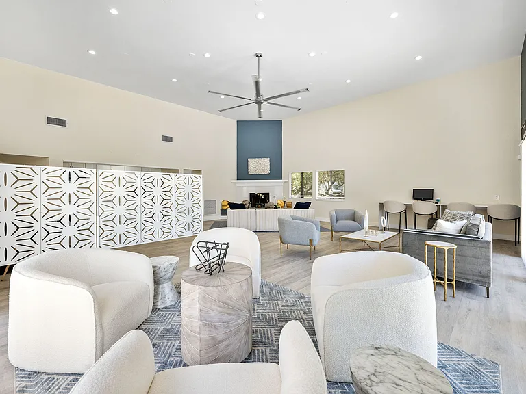 Elegant communal lounge with modern furnishings, cozy seating, and a stylish decorative divider, perfect for relaxation and socializing.