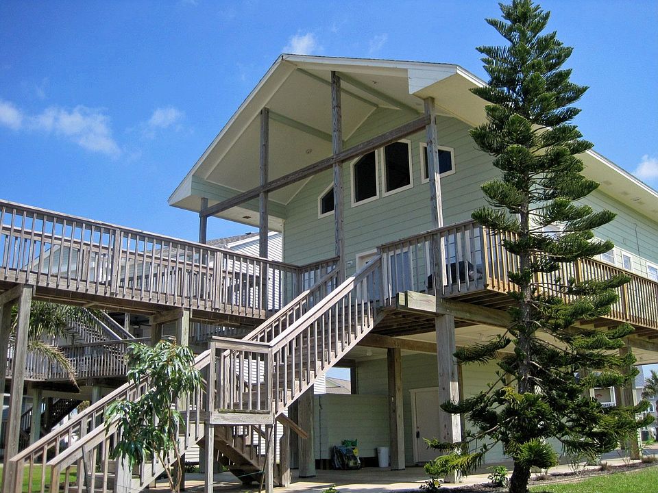 Front of home with new landscaping, boat house & lift, and wrap around deck. 