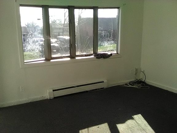 Large, sunlit living room with view of quiet neighborhood