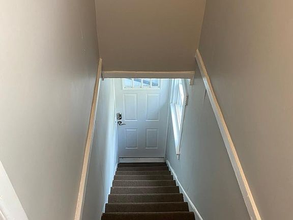Stairwell facing down toward exterior door for unit (railing being added)
