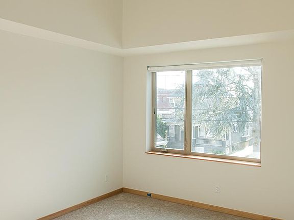 Bedroom 1 (south facing): high ceiling and picture window.