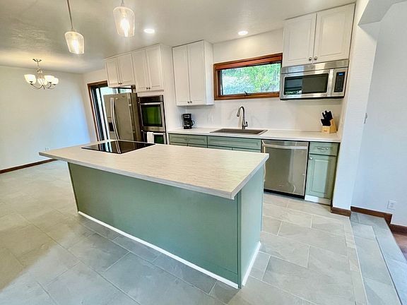 Kitchen island with bar-seating, overhead lighting, and electric stove top