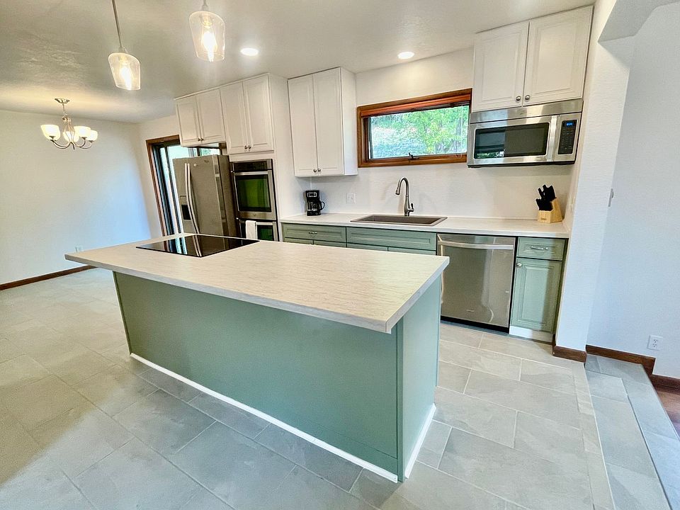 Kitchen island with bar-seating, overhead lighting, and electric stove top
