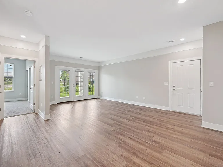 Dooley's Orchard unit showing a living room with wooden flooring and white walls.