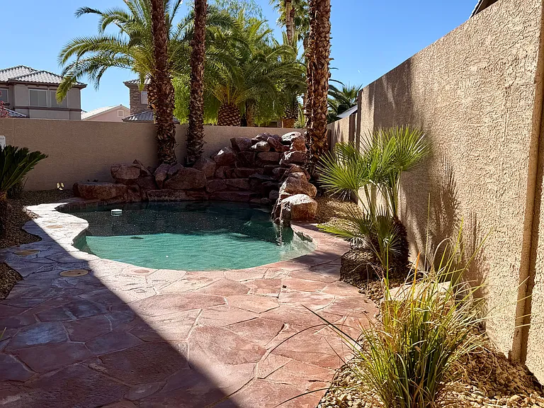 Resort-sytle pool with rock waterfall and lush landscaping