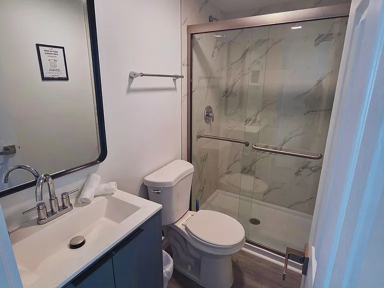 Impeccable bathroom with toilet, shower, sink, and towel set