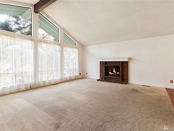 Additional view of the living room showing the floor to ceiling windows that let in plenty of natural light.