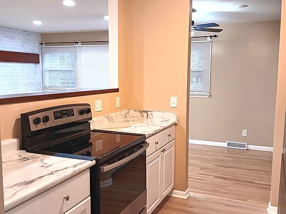 Kitchen, with new stainless steel appliances, connects to living area for easy conversation.