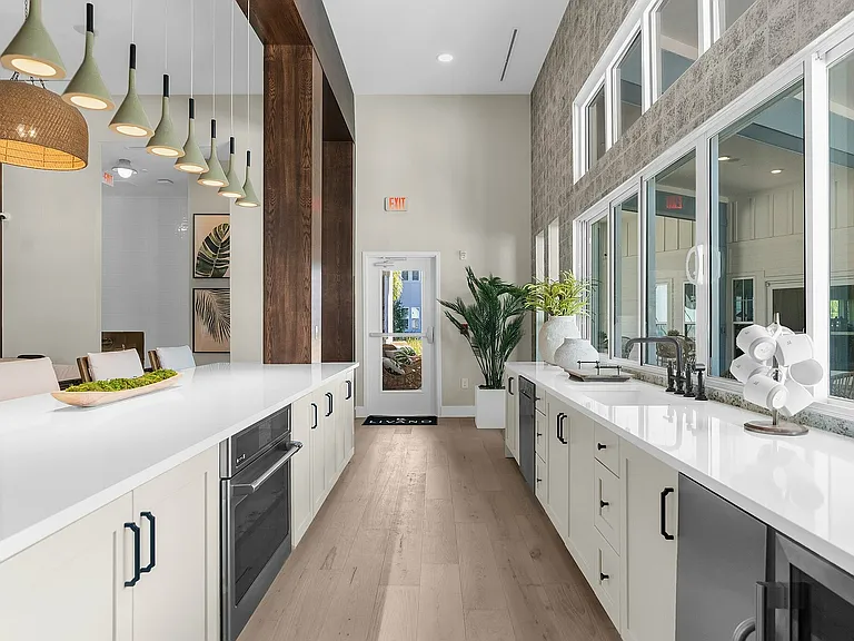 Experience modern elegance in this kitchen, featuring expansive countertops and stylish lighting.