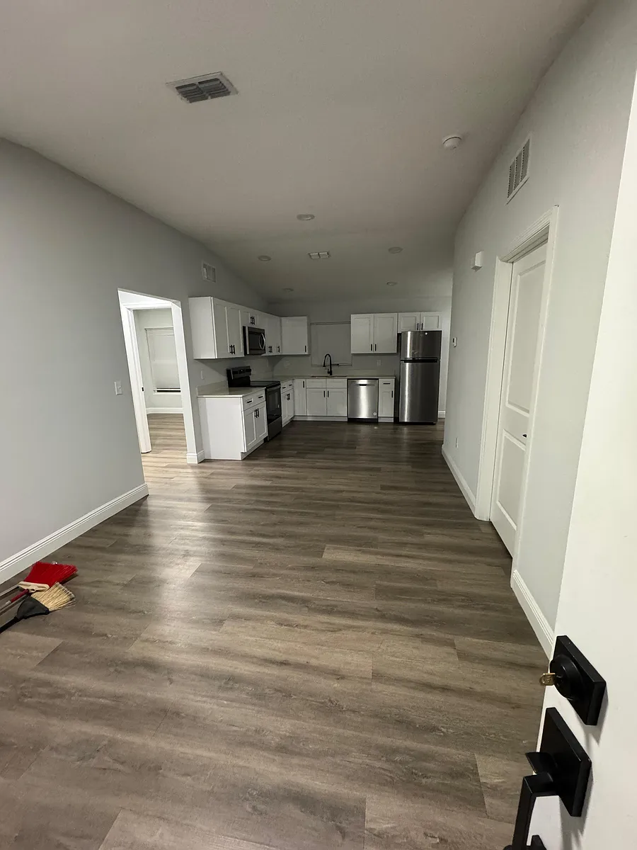 Open kitchen with white cabinetry, stainless-steel appliances, and generous counter space flowing into the main living area. - Dogwood Ct