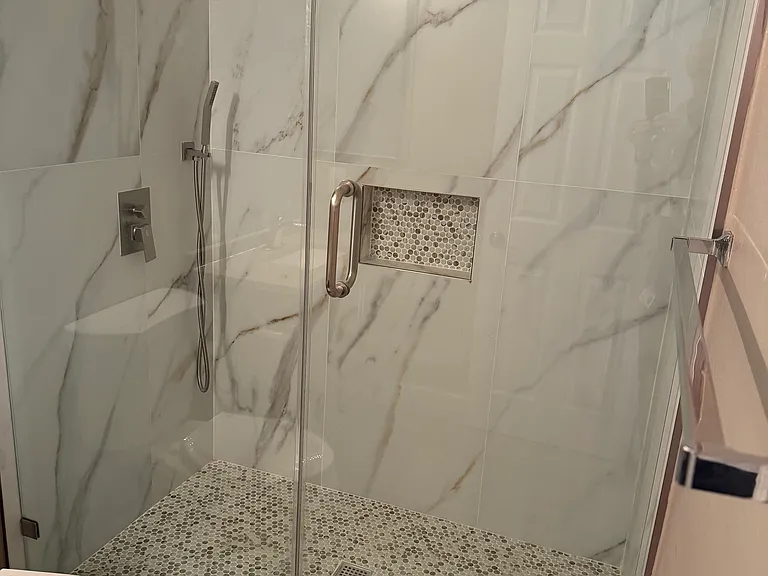 Primary remodeled bath with Quartz and frameless glass enclosure.