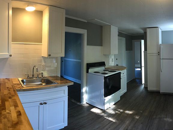 Beautiful, new kitchen! Front hall entry door featured to the right of the stove.