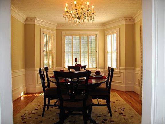 Dining room features bay window, crystal chandelier and plantation shutters