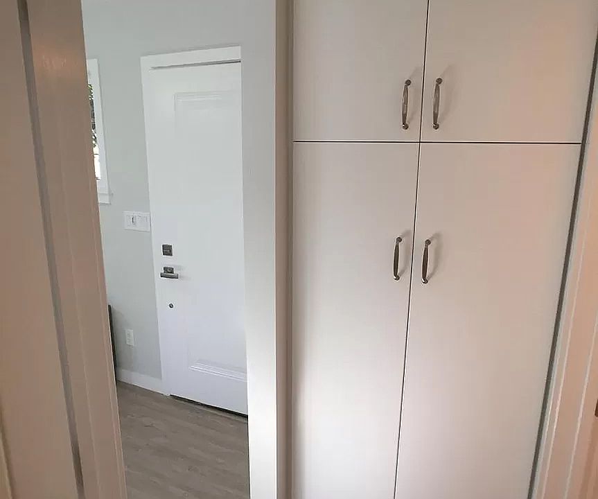 coat closet/cleaning tools with shelves above
