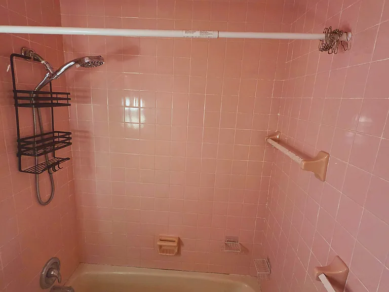 Spacious tub and shower combo for a relaxing and comfortable experience.