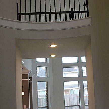 2 story rotunda with a glimpse into the living room with floor to ceiling windows!