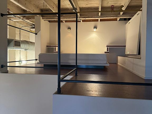 Lofted space with built-in queen bed and mattress.